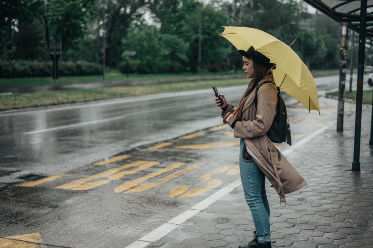 Woman in rain at bus stop